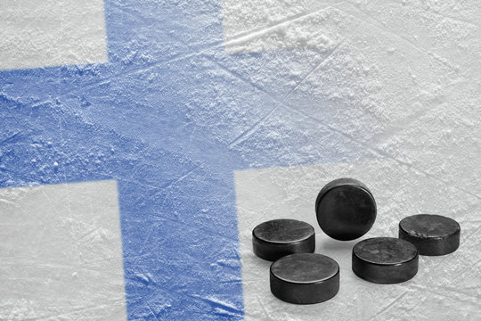 Hockey pucks and the image of the Finnish flag on ice