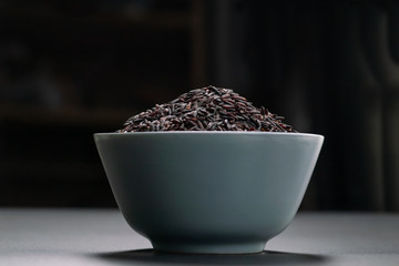 bowl of jasmine black rice on black backgrounds
