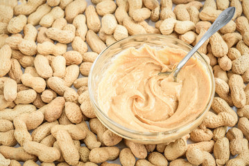 Peanut butter and peanuts on white background.