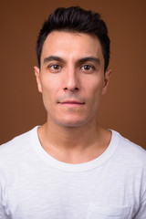 Fototapeta premium Young handsome Hispanic man against brown background