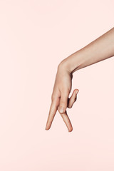 cropped image of woman showing gesture with two fingers down isolated on pink background
