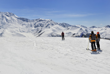 Fototapeta na wymiar skiers on slopes in snowy alpine mountains 