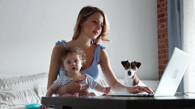 Young businesswoman with a child working with computer at home.