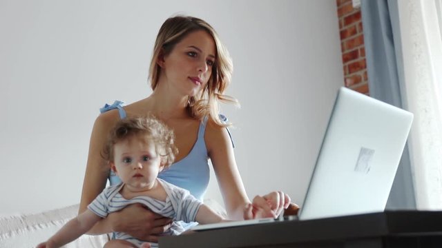 Young businesswoman with a child working with computer at home.