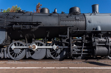 Old locomotive steam engine details. Detail of steam locomotive, side view, wheels, rods, part of the boiler