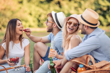 Happy friends on picnic in park