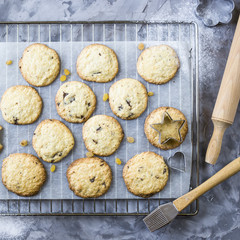 Homemade oatmeal cookies with chocolate chips on a gray kitchen table among accessories for baking. Top view, flat lay
