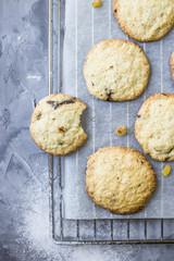 Homemade oatmeal cookies with chocolate chips on a gray kitchen table among accessories for baking. Top view, flat lay
