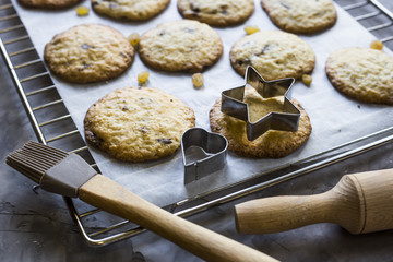 Homemade oatmeal cookies with chocolate chips on a gray kitchen table among accessories for baking