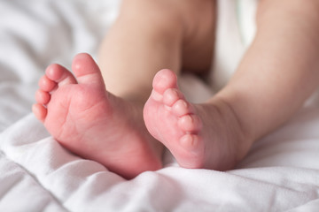 Obraz na płótnie Canvas Beautiful image of the feet of a newborn baby on a white blanket