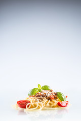 Spaghetti bolognese basil tomatoes and parmesan cheese on white background