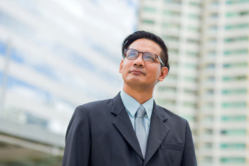Fototapeta premium Asia young business man in front of the modern building in downtown .Concept of young business people