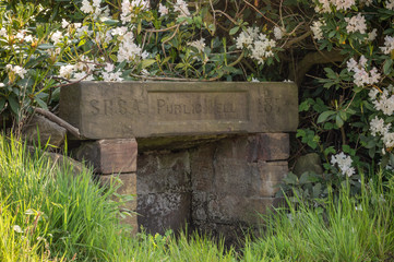 An old nineteenth century Staffordshire Rural Sanitary Authority stone public drinking well.