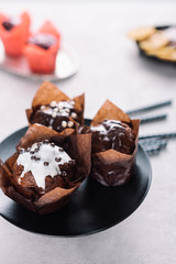 Sweet chocolate muffins with glaze served on plate