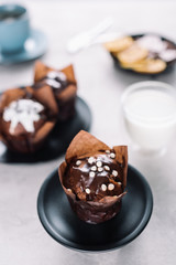 Sweet chocolate muffins with glass of milk on table