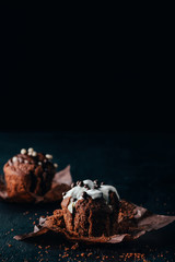 Sweet muffins with chocolate chips on dark table