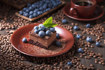  Chocolate cake on a old wooden table with coffee beans.