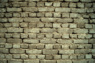 background of a gray, old brick wall, built on clay