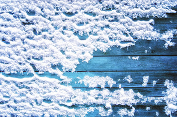 Blue wooden background in white snow