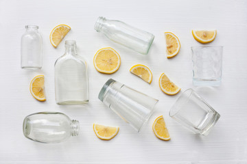 Fototapeta na wymiar Glasses and bottle for drinks with lemon slices. Healthy vitamin drink.