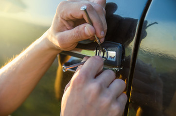 closeup hand of thief try to break into car with screwdriver (theft concept)