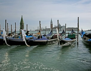 Fototapeta na wymiar Many gondolas parked in the Venetian lagoon photographed with th