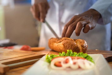 french bread burger being prepapre by chef in the kitchen
