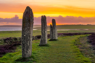 Theree standing stones of the ancient and mysterious Ring of Brodgar underneath a dramatic sunset - obrazy, fototapety, plakaty