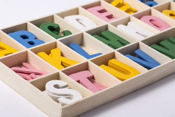 Alphabet letters on wooden scrabble pieces, isolated on white.