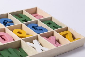 Alphabet letters on wooden scrabble pieces, isolated on white.