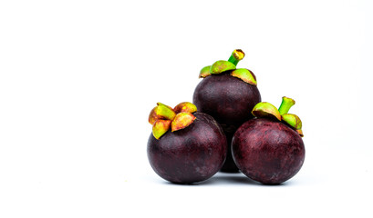 Whole mangosteen showing purple skin isolated on white background with space. Tropical fruit from Thailand. The queen of fruits. Asia fresh fruit market concept. Natural source of tannin and xanthones