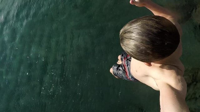 young beautiful man boy 14 years old play and swim or jump in the water. crazy and joyful youth concept  for traveler vacation at the sea. water activity leisure 