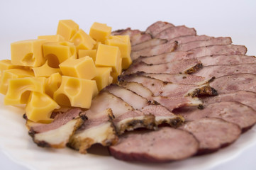 homemade sausage and bacon cut into thin slices with cheese on white