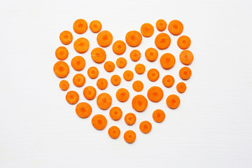 Chopped carrot slices heart shape isolated .