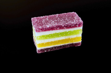 Multicolored marmalade in sugar on a dark background
