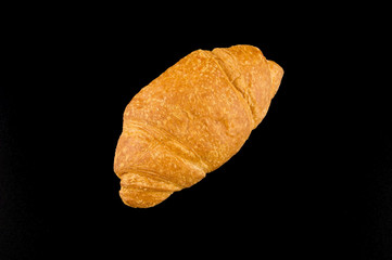 Golden croissant with cherry jam on a dark background