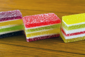 slices of colorful marmalade on a wooden background