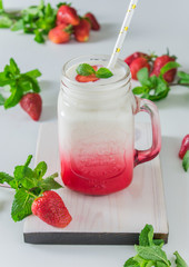 Strawberry yogurt in a jar on a light background