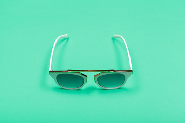 Top view. Fashion sunglasses on pastel background