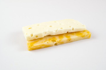 Pieces of marbled cheese and brinza on a light background