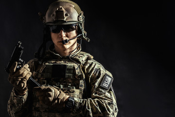 Special forces soldier with rifle on dark background
