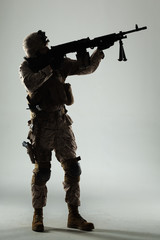 Soldier in camouflage holding rifle