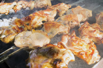 Large pieces of juicy chicken meat on the grill