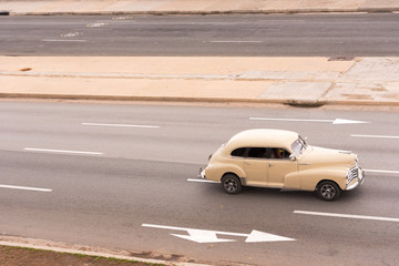 Fototapeta na wymiar CUBA, HAVANA - MAY 5, 2017: American beige retro car on city street. Сopy space for text.