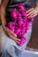 Bouquet of bright pink peonies in hands.