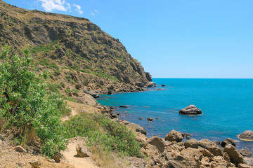 Fototapeta na wymiar Sea and rocks landscape at Cape Meganom, the east coast of the peninsula of Crimea. Colorful background. Travelling concept. Copy space.