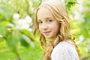 portrait of a beautiful girl in a blooming apple orchard