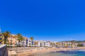 Fototapeta na wymiar SITGES, CATALUNYA, SPAIN - JUNE 20, 2017: View of the sandy beach and promenade. Copy space for text.