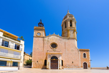 Fototapeta premium SITGES, CATALUNYA, SPAIN - JUNE 20, 2017: View of the church of of Sant Bartomeu and Santa Tecla. Copy space for text.
