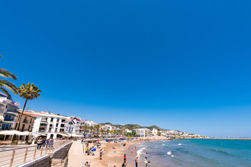 Obraz premium SITGES, CATALUNYA, SPAIN - JUNE 20, 2017: View of the sandy beach and promenade. Copy space for text.